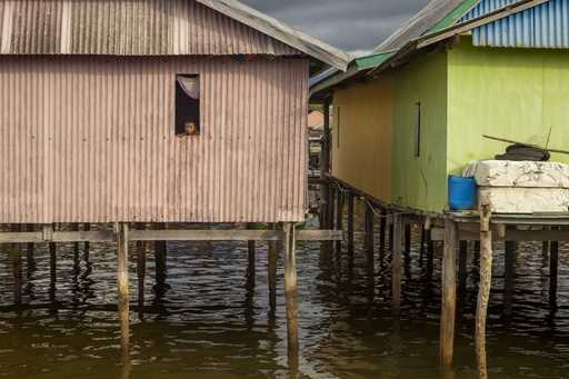 A boy looks out from the window of his house on Kabaena Island, Indonesia, Friday, November 15, 202…