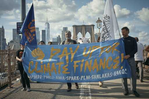 Protesters cross the Brooklyn Bridge during a Youth Climate Strike march to demand an end to the er…