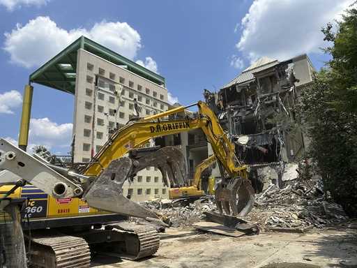 Workers knock down a former Coca-Cola Co