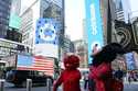 Costumed characters pass the Nasdaq MarketSite during the Coinbase IPO, in New York's Times Square,…