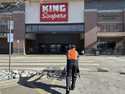 An employee pushes a string of shopping carts back into a King Soopers grocery store for customers'…