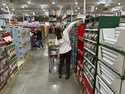 Shoppers reach for items on display in a Costco warehouse November 19, 2024, in Lone Tree, Colo