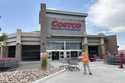 A worker collects shopping carts in front of a Costco warehouse on July 16, 2024, in Sheridan, Colo…