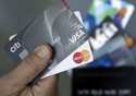 FILE- An unnamed person holds two Visa and Mastercard credit cards in Haverhill, Mass