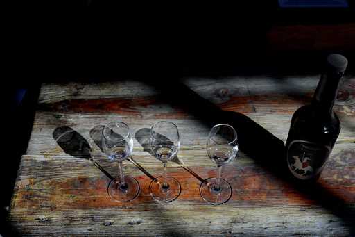 A bottle of Cyprus' famous Commandaria wine sits next to three glasses at the Karseras Winery in th…