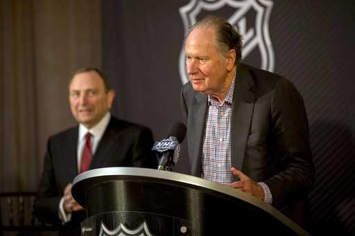 Seattle Kraken founding owner David Bonderman, right, steps up to the podium after the National Hoc…