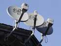 Dish Network satellite dishes are shown at an apartment complex in Palo Alto, Calif