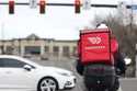 A food delivery rider waits for the traffic light to change Monday, March 30, 2020, in Lone Tree, C…