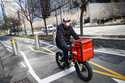 A delivery worker rides his bicycle along a path on the West Side Highway in New York, March 16, 20…