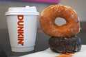 Two donuts and a cup of coffee rest on a counter at a Dunkin' location, Friday, January 10, 2025, i…