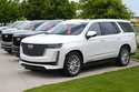 Unsold 2024 Escalade utility vehicles sit in a row outside a Cadillac dealership on June 2, 2024, i…