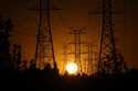 The sun sets behind high tension power lines on Sept