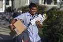 United States Postal Service letter carrier Gabriel Peña carries mail in Los Angeles on March 22, 2…