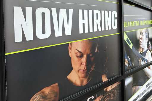 A hiring sign is displayed at a fitness center in Riverwoods, Ill