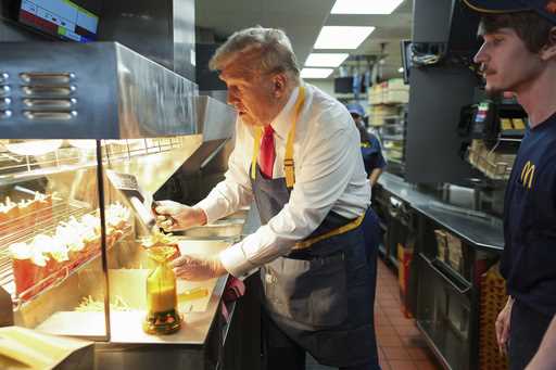 Republican presidential nominee former President Donald Trump serves french fries as an employee lo…