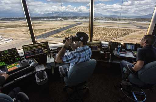 Air traffic controllers watch for traffic from the control tower at the Tucson International Airpor…
