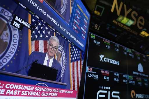 A screen displays a news conference with Federal Reserve Chairman Jerome Powell on the floor at the…