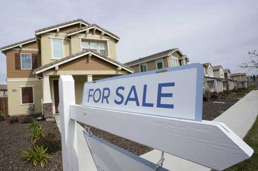 A for sale sign is posted in front of a home in Sacramento, Calif