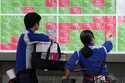 People watch an electronic stock board showing Japan's Nikkei index at a securities firm in Tokyo, …