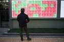 A person looks at an electronic stock board showing Japan's Nikkei index at a securities firm in To…