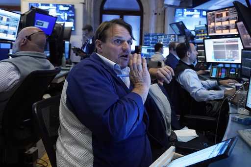 Trader Michael Milano, center, works with colleagues on the floor of the New York Stock Exchange on…