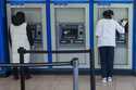 A customer makes a transaction at a bank of automatic teller machines in the Queens borough of New …