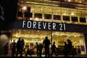 Shoppers walk by a Forever 21 clothing store, Thursday, October 24, 2019, in Tokyo, as the liquidat…