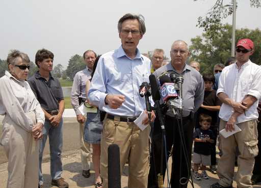 Charles McMillan, center, director of Los Alamos Laboratory, talks to reporters during a news confe…