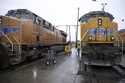 A Union Pacific worker walks between two locomotives being serviced in a railyard in Council Bluffs…