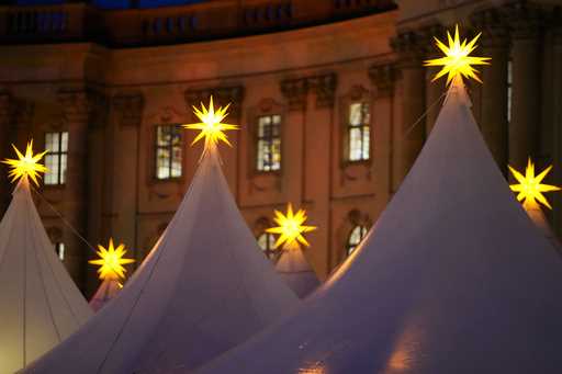 Christmas stars illuminate the top of the tents of the Christmas market at Bebelplatz in the city c…