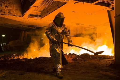 An employee in protective clothing works at the furnace at the steel producer, the Salzgitter AG, i…