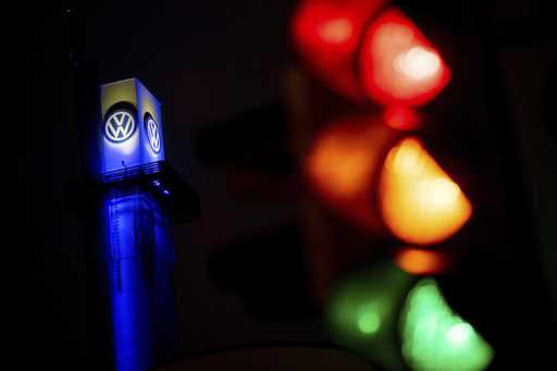 A traffic light shines in front of a Volkswagen logo at the Volkswagen plant in Osnabruck, Germany,…