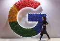 In this November 5, 2018 file photo, a woman walks past the logo for Google at the China Internatio…