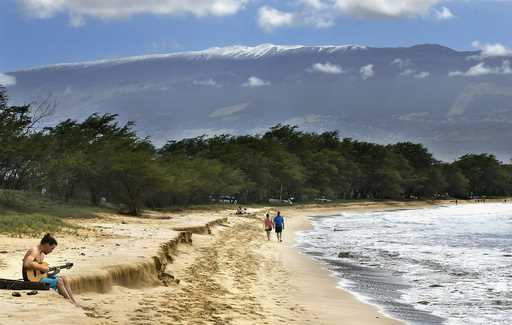 FILE -- Snow-capped Haleakala serves as a backdrop as Paia, Maui's Scott Picton, left, plays a guit…