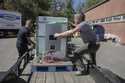 Henry Kovacs, left, and Hayden Wilson, right, volunteers with the Footprint Project, load two Tesla…