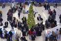 Holiday travelers wait in line to check their bags at the JetBlue terminal at Logan Airport, Friday…