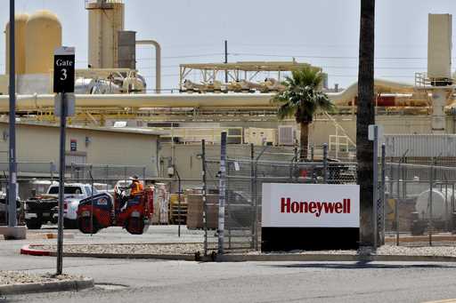 Construction workers pave a parking lot at a Honeywell plant on April 4, 2020, in Phoenix