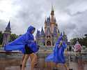 Guests at the Magic Kingdom at Walt Disney World brave wind and rain as bands of weather from Hurri…