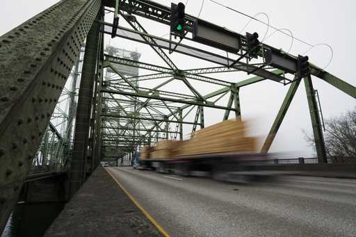 A logging truck drives on the Interstate 5 bridge that spans the Columbia River and connects Portla…