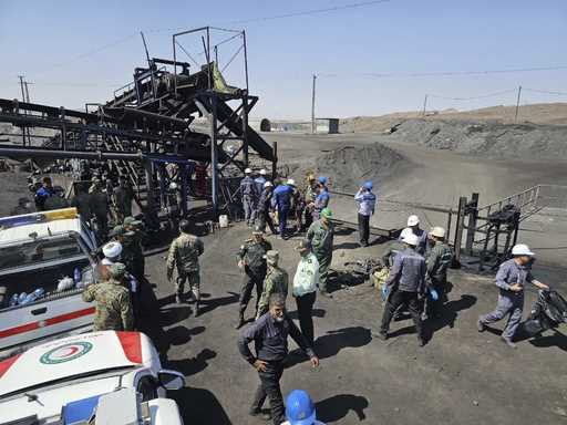 In this photo released by Iranian Red Crescent Society, miners and police officers are seen at the …