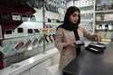 A cellphone vendor works at her shop in downtown Tehran, Iran, Wednesday, February 21, 2024