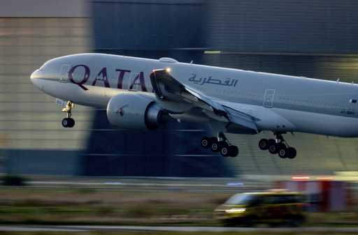 A Qatar airways plane lands at the airport in Frankfurt, Germany, as the sun rises on Sept