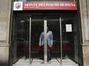 A man waits for the sliding doors to open to exit a Monte dei Paschi di Siena bank branch, in Milan…