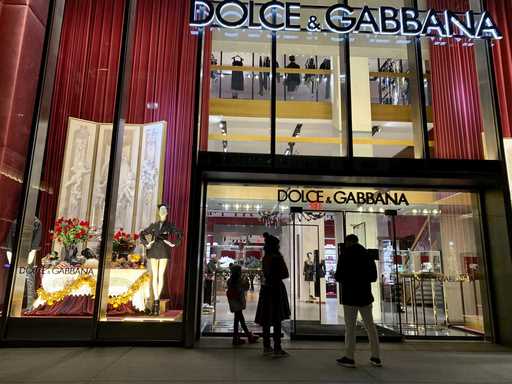 People stand outside the Dolce & Gabbana store on Fifth Avenue, November 21, 2021, in New York