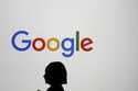 A woman walks by a giant screen with a logo at an event at the Paris Google Lab on the sidelines of…