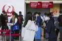 A staff member of Japan Airlines helps customers at Osaka International Airport on the outskirts of…