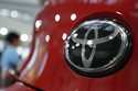 People walk by the logo of Toyota at a show room in Tokyo, August 2, 2019