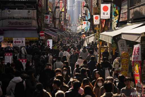 People crowd the famed "Ameyoko" shopping street on New Year's Eve in Tokyo, Tuesday, December 31, …