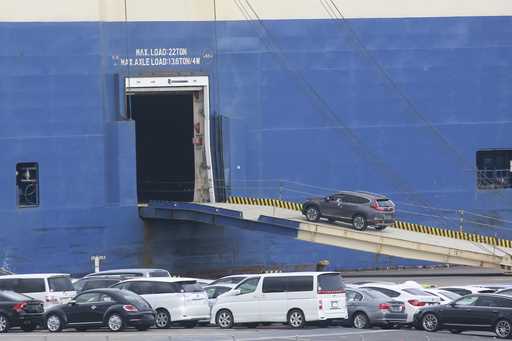 Cars for export are loaded onto a cargo ship at a port in Yokohama, near Tokyo, November 2, 2021