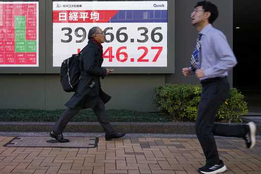 An electronic stock board showing Japan's Nikkei index at a securities firm is seen through the win…